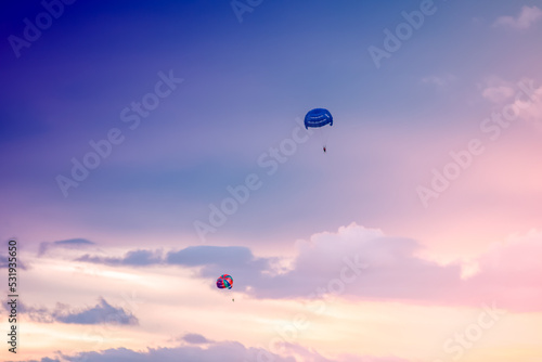 Parasailing on sunset and blue sky background in tropical country