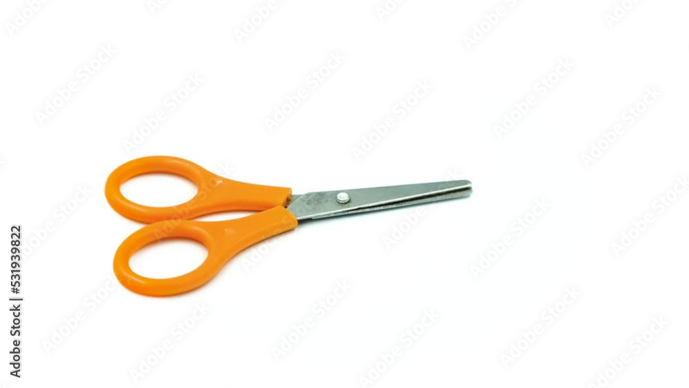 Orange scissors rotating on a white background Orange scissors rotating on a white background