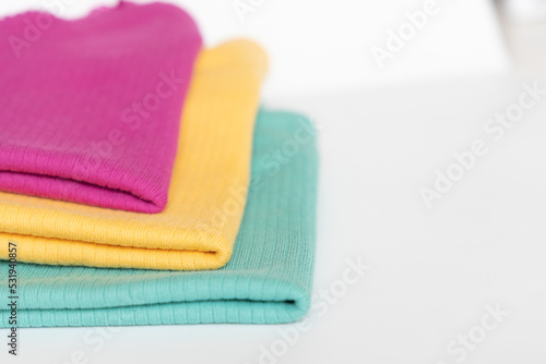 Stack folded colorful baby cotton clothing on white background isolation. Copy space. For advertising, commercial,mock up.