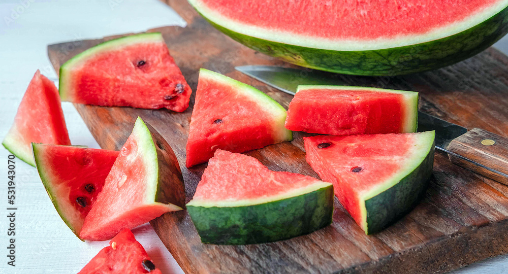 Close up of tasty sliced fresh watermelon on a wooden chopping board Close up of tasty sliced fresh watermelon on a wooden chopping board
