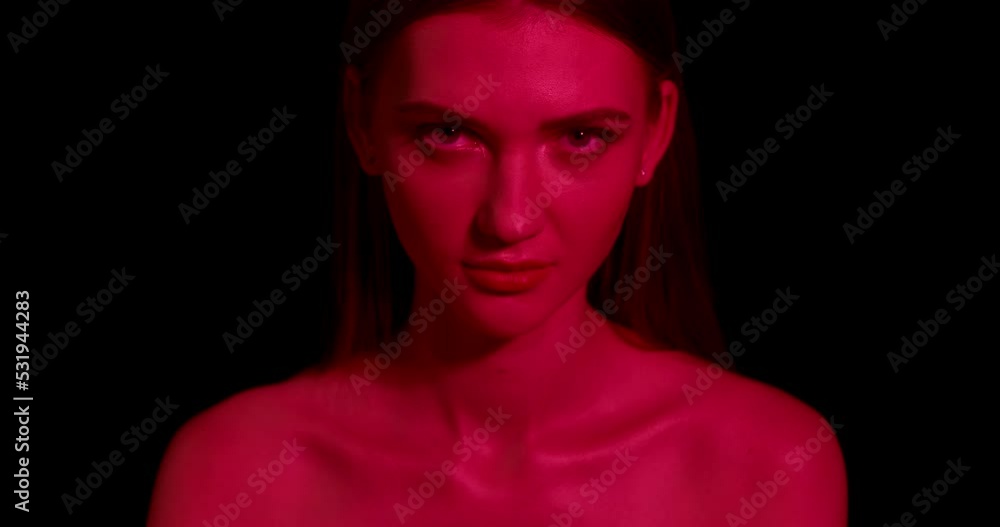Sexy and beautiful young woman with neon lighting looks at the camera. Fashion model portrait. Sexy and beautiful young woman with neon lighting looks at the camera. Fashion model portrait.