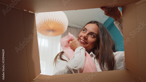 Valokuva Portrait of happy girl unpacking delivery parcel sitting at home