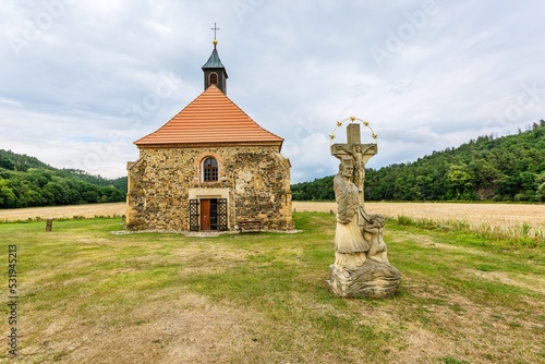 Obraz na płótnie Dolany, Czech Republic - July 30 2022: View of gothic church from 13th century made of stone dedicated to Saint Peter and Paul. The statue of John of Nepomuk in the foreground. w salonie