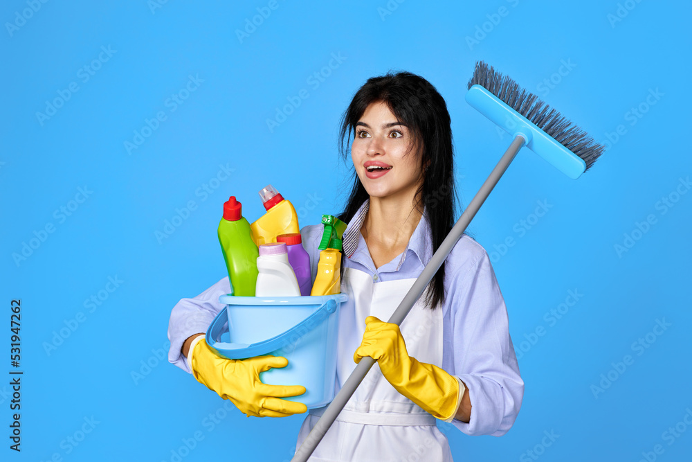 woman in gloves holding bucket of detergents and broom woman in gloves holding bucket of detergents and broom