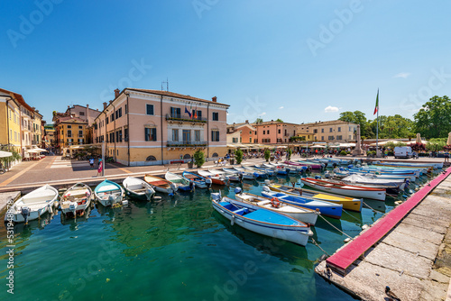 Small old port of the village of Bardolino with many boats moored. Tourist resort on the coast of Lake Garda (Lago di Garda). Verona province, Veneto, Italy, southern Europe.