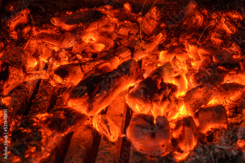 Red hot burning coals in fireplace texture or background.