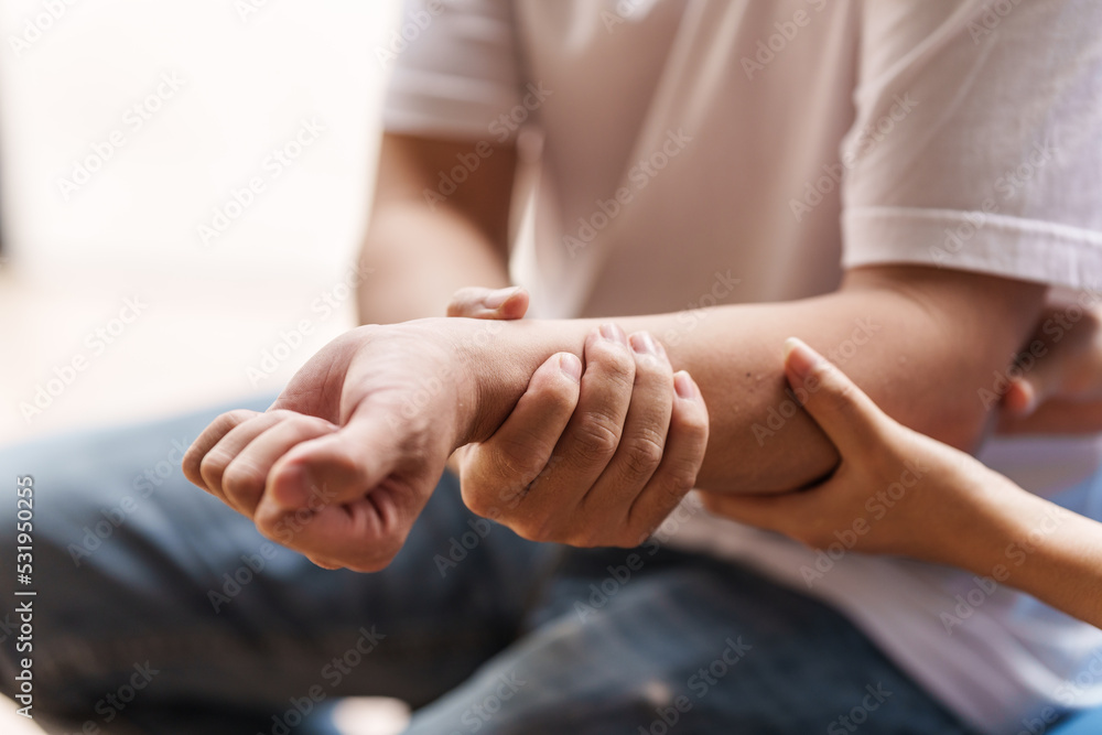 Physical therapist is examining the injured arm, waist and neck muscles of an athletic male patient. Physical therapist is examining the injured arm, waist and neck muscles of an athletic male patient.