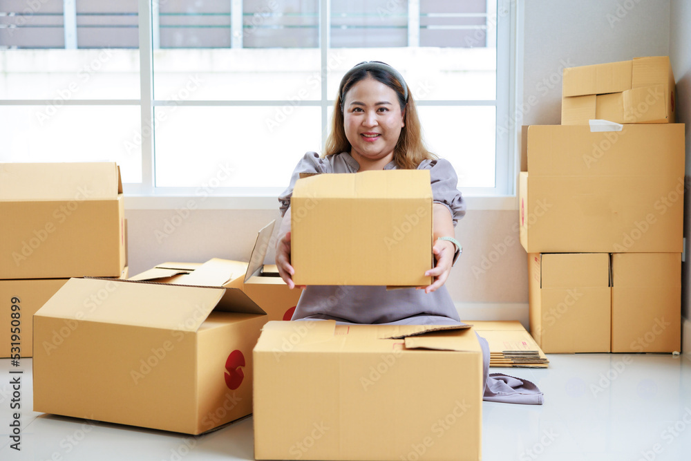 Asian woman startup packaging business, holding parcel box, order by online at her home. Asian woman startup packaging business, holding parcel box, order by online at her home.