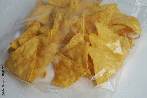 Mexican corn chip Nachos in transparent  single use plastic bag on white background