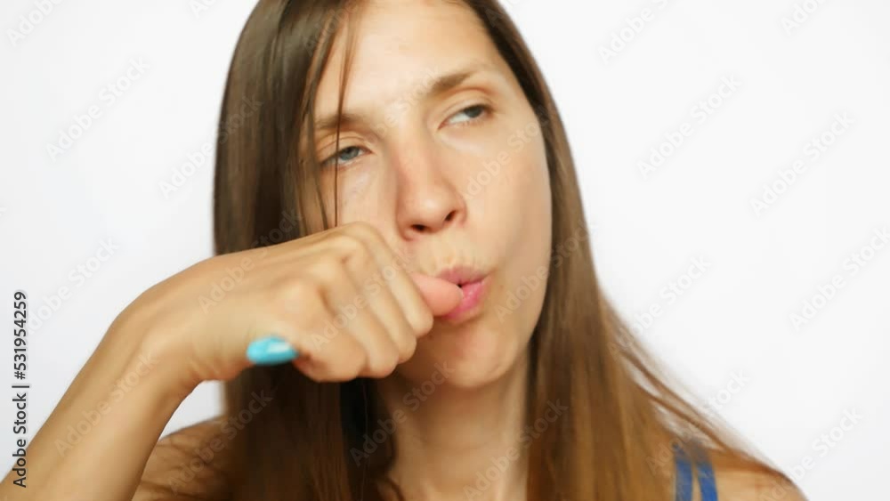 Close-up of a beautiful young woman brushing her teeth against white background Close-up of a beautiful young woman brushing her teeth against white background