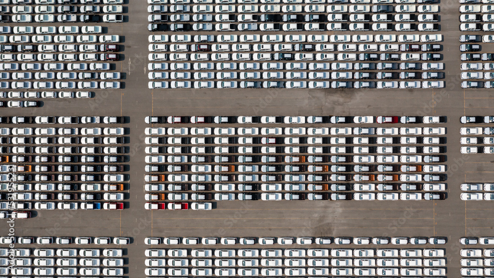 Aerial top view parked new cars at the automotive plant, new car lined up in the port for import and export business logistic to dealership for sale, Automaker distribution center with new vehicles. Aerial top view parked new cars at the automotive plant, new car lined up in the port for import and export business logistic to dealership for sale, Automaker distribution center with new vehicles.