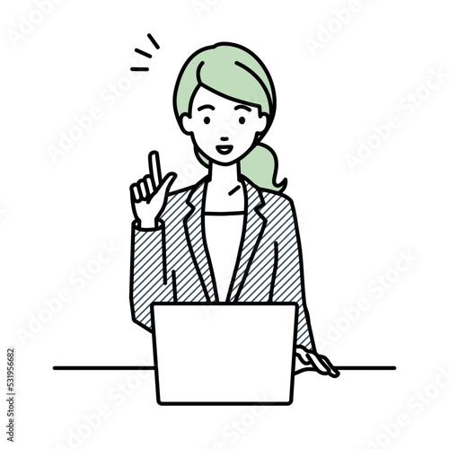 デスクで座ってPCを開いて何かひらめいたスーツの女性