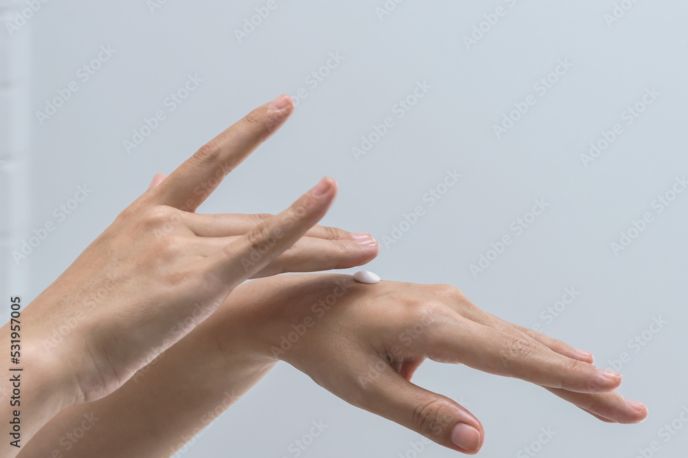 Close up woman hands with moisturizing anti aging cream on white background, Hands concept Close up woman hands with moisturizing anti aging cream on white background, Hands concept