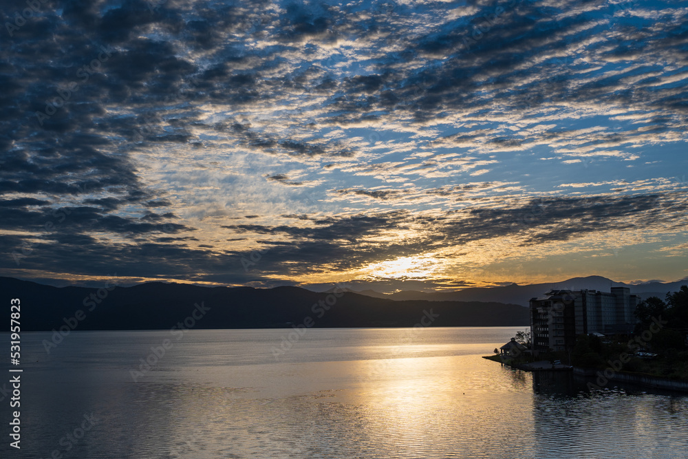 洞爺湖上のうろこ雲の色を変えていく朝日