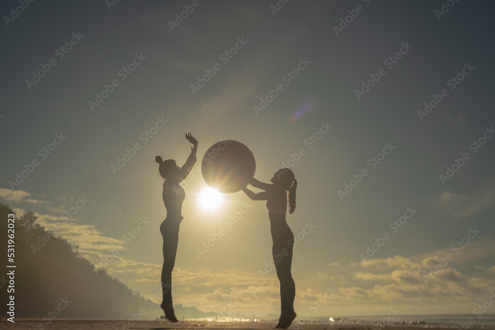 Two Asian women Practicing Yoga On Beach At Sunset, Beautiful Woman Summer Vacation Meditation Seaside Sea Ocean Holiday Travel