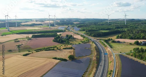 power generating wind turbines and modern solar panels in the countryside (aerial)