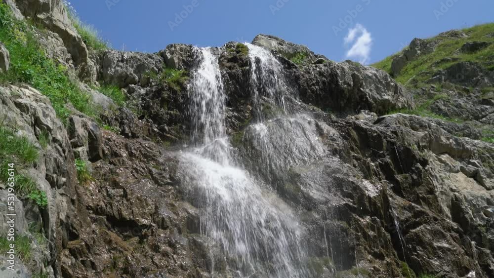Waterfall cascade on mountain cliffs. Melting glacier in the mountains. Waterfall cascade on mountain cliffs. Melting glacier in the mountains.