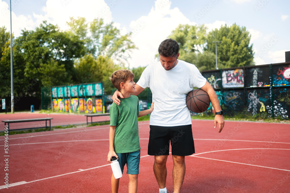 Father and son connect through sports activities, play basketball and enjoy a sunny day