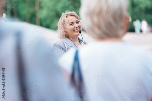 Obraz na płótnie female tour guide with a microphone standing among a group of tourists. w salonie