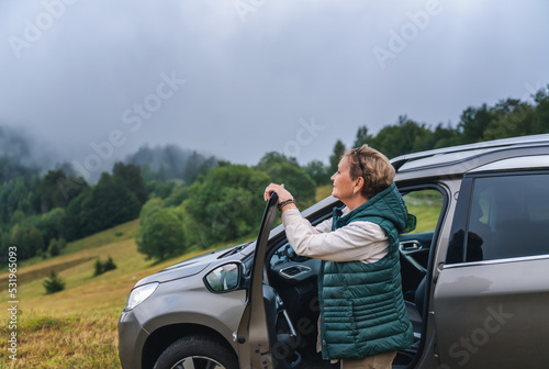 Beautiful happy gray-haired mature traveling by car. Active pensioners lifestyle concept © olezzo