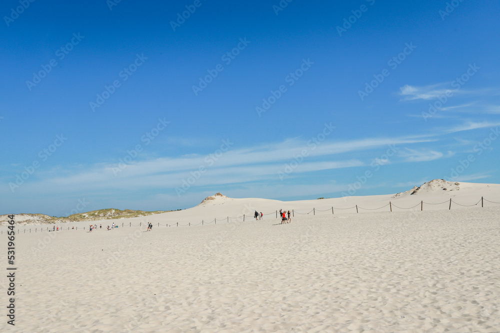 Rippled sand background, dune and see in Slowinski National Park, Leba, Poland. Beautiful scenery of sand dunes and ocean. Rippled sand background, dune and see in Slowinski National Park, Leba, Poland. Beautiful scenery of sand dunes and ocean.
