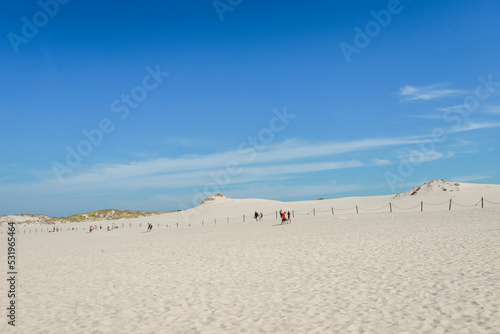 Rippled sand background, dune and see in Slowinski National Park, Leba, Poland. Beautiful scenery of sand dunes and ocean.