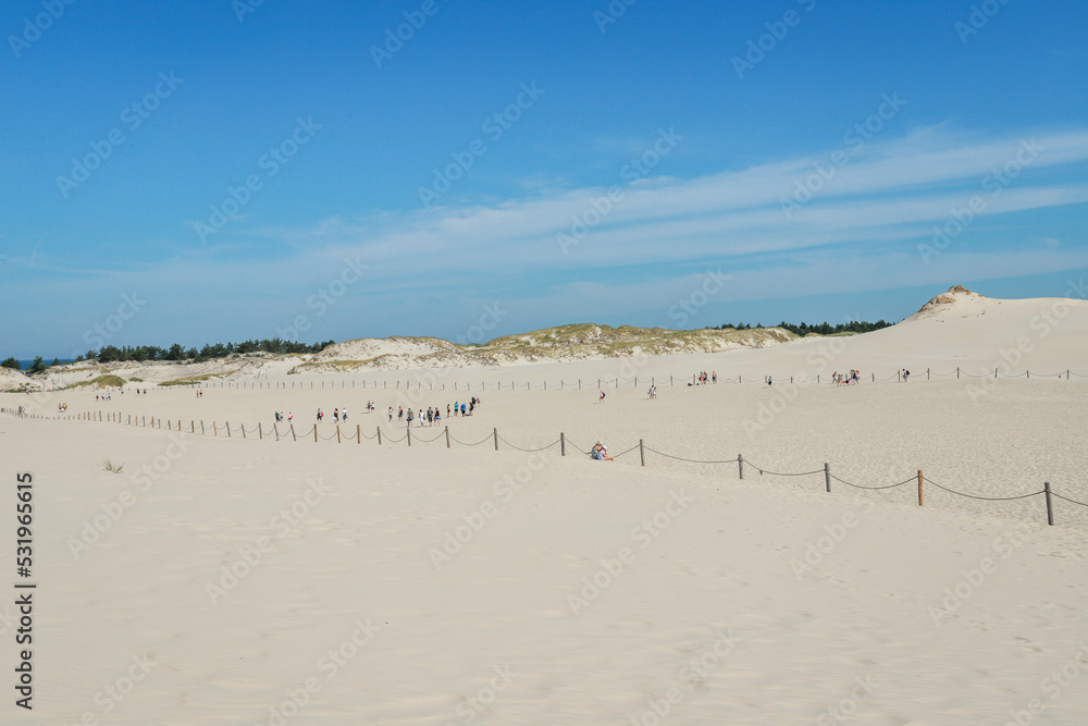 Rippled sand background, dune and see in Slowinski National Park, Leba, Poland. Beautiful scenery of sand dunes and ocean. Rippled sand background, dune and see in Slowinski National Park, Leba, Poland. Beautiful scenery of sand dunes and ocean.