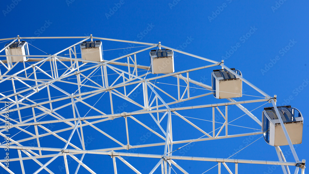 Ferris wheel ride against clear blue sky