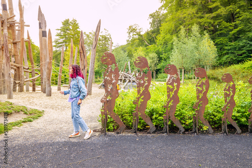 Billede på lærred Funny modern homo sapiens girl in a row of prehistoric ancestors on a children playground near the Neanderthal Museum near Dusseldorf