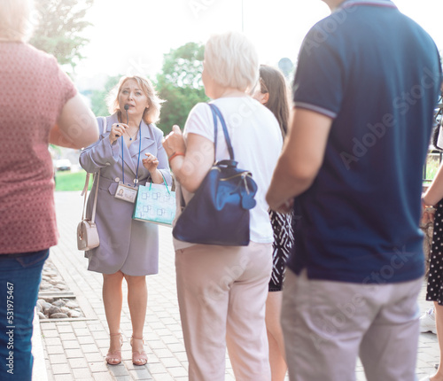 female guide is telling a group of tourists about something.