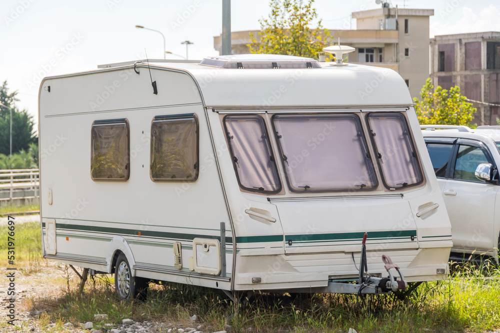 Motor home stands in a parking lot in the city next to the park.