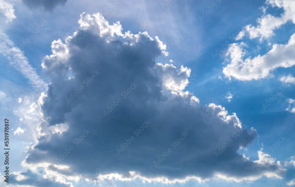 Obraz premium The sun is behind the cloud. Summer sky. Clouds illuminated by the sun from behind.