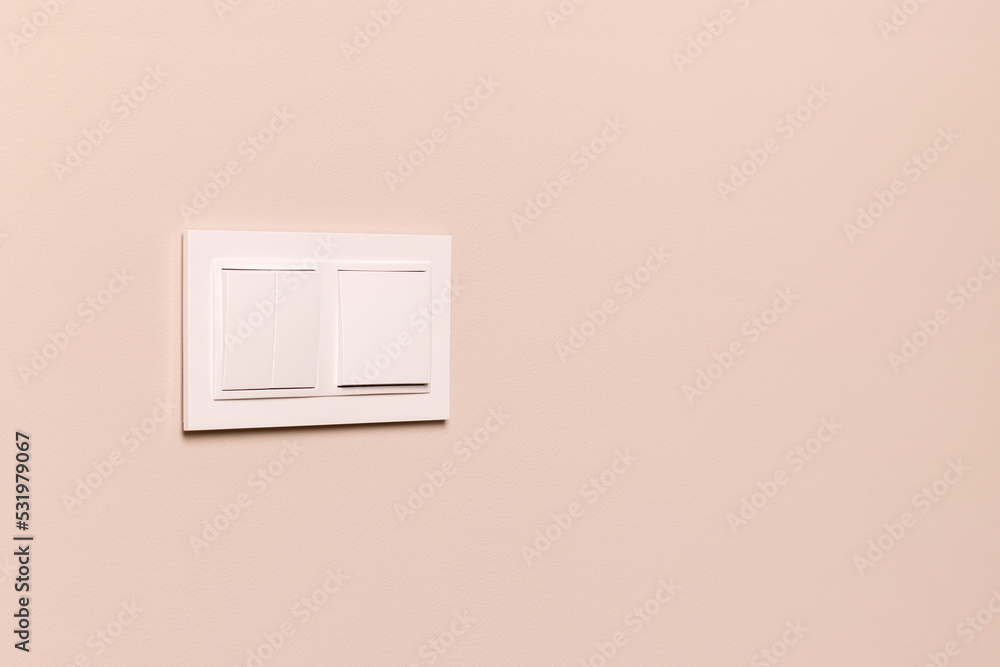 Group of white electrical switches on modern beige wall Group of white electrical switches on modern beige wall
