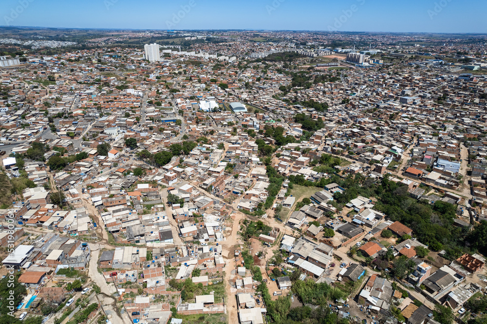 Fototapeta premium Aerial view of Parque Oziel neighborhood (also known as Jardim Monte Cristo) in Campinas, São Paulo. Poor community with wooden houses, garbage and vegetation in its surroundings.