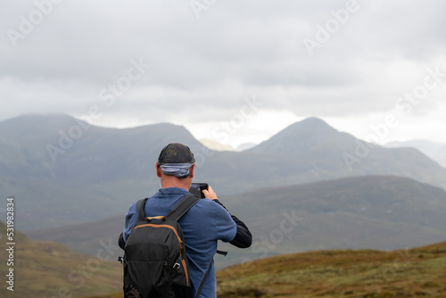 Hiker taking a picture with his mobile of the Scottish mountains. West highland way. High quality photo