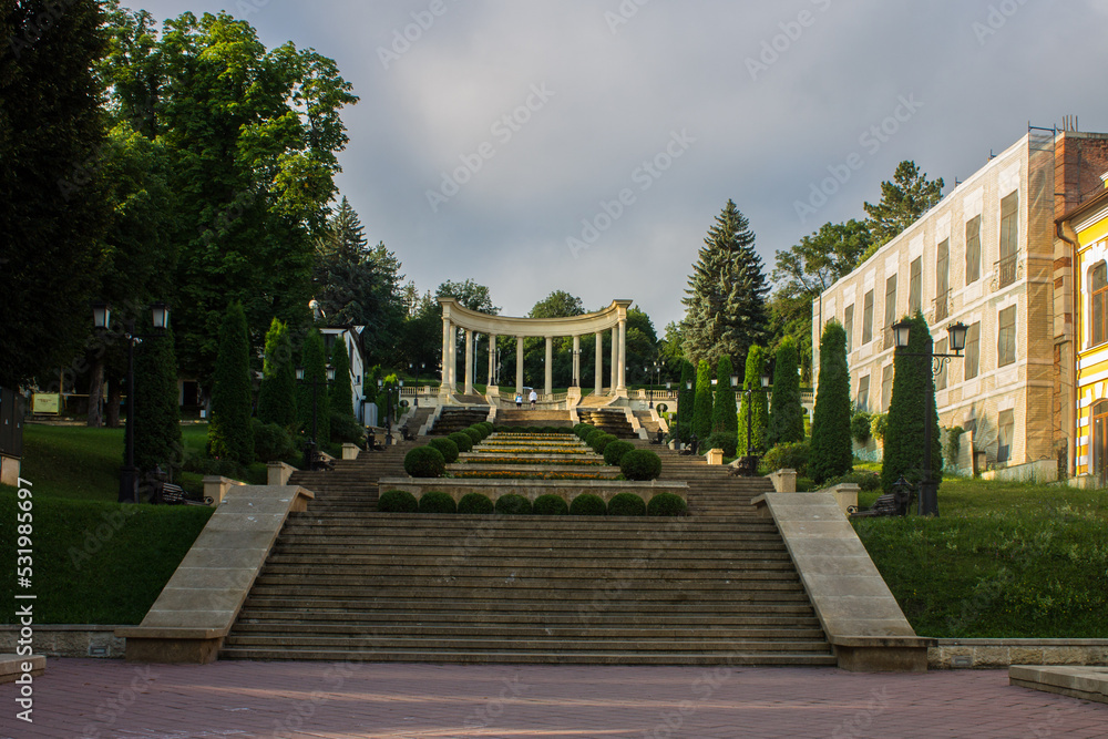 Kislovodsk, Stavropol Territory, Russia - July, 22, 2022: Frontal perspective of a cascade staircase with a colonnade in the historical center of the city on a summer day