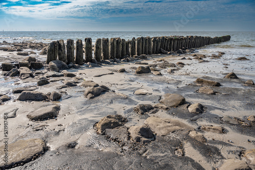 Alte Uferbefestigung aus Holzpfählen am Strand von Borkum photo