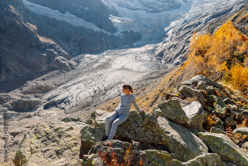 Hiker woman in mountains. Mountain with glacier and tourist