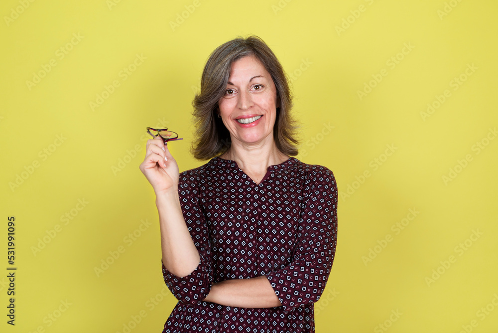 Portrait of a smiling middle-aged woman on a yellow background
Portrait of a smiling middle-aged woman on a yellow background