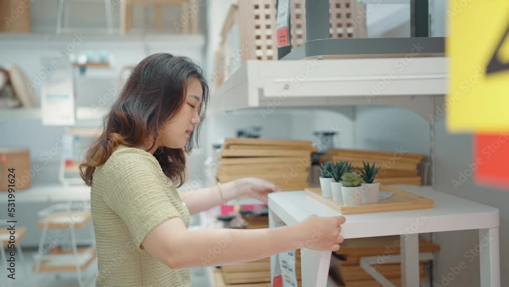 Asian woman measuring furniture with measure tape in furniture store Asian woman measuring furniture with measure tape in furniture store