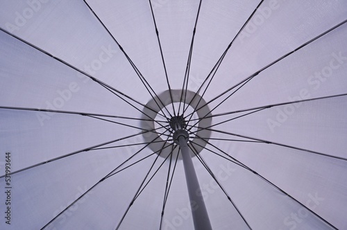 Umbrella abstract. Low angle on opened umbrella. Parasol view from bottom. Closeup of umbrella.