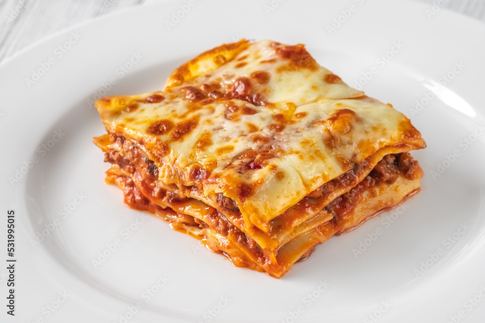 Portion of lasagne on white plate Portion of lasagne on white plate