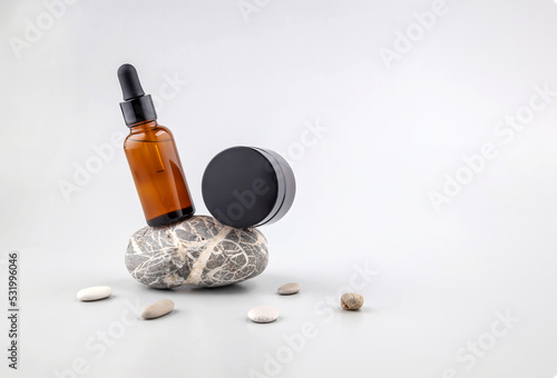 balancing containers for cosmetics on the podium made of stone on a gray background
