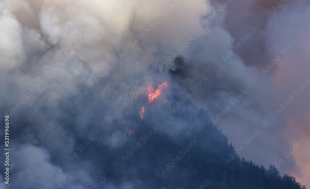 BC Forest Fire and Smoke over the mountain near Hope during a hot sunny summer day. British Columbia, Canada. Wildfire natural disaster BC Forest Fire and Smoke over the mountain near Hope during a hot sunny summer day. British Columbia, Canada. Wildfire natural disaster