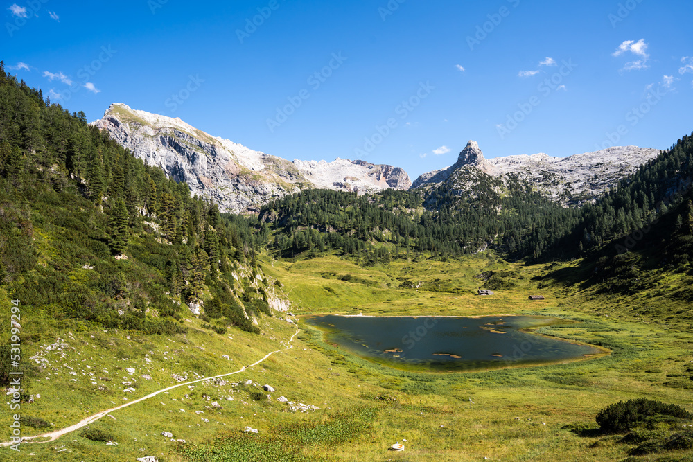 View over a green valley with a mountain lake in the middle