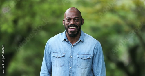 Happy African man smiling outside. Joyful black ethnicity person standing
