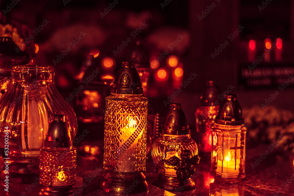 burning candles in lanterns at night in the cemetery burning candles in lanterns at night in the cemetery