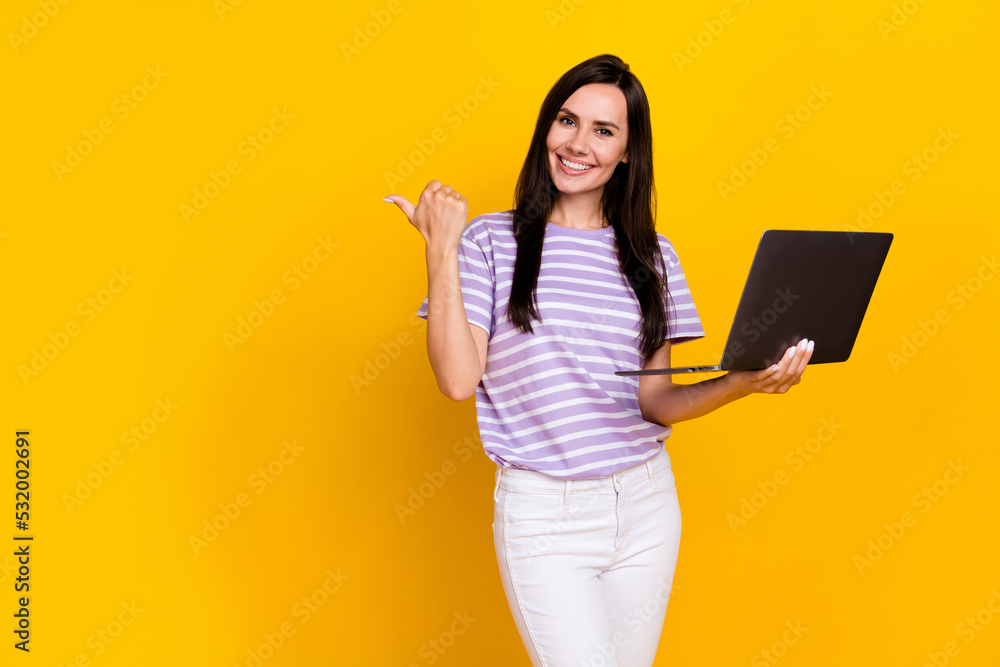 Photo of charming positive lady arm direct empty space offer quality cool modern device gadget netbook isolated on yellow color background Photo of charming positive lady arm direct empty space offer quality cool modern device gadget netbook isolated on yellow color background