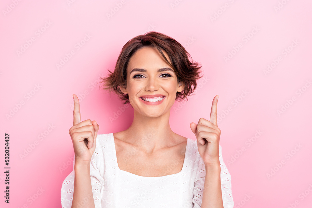 Photo portrait of stunning young lady directing up empty space shopping banner wear stylish white clothes isolated on pink color background Photo portrait of stunning young lady directing up empty space shopping banner wear stylish white clothes isolated on pink color background