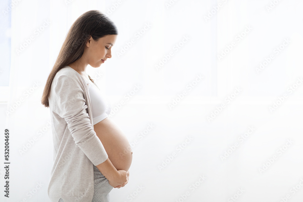 Beautiful caucasian expecting woman hugging her tummy Beautiful caucasian expecting woman hugging her tummy